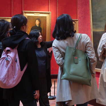 Group of people looking at and discussing paintings around them