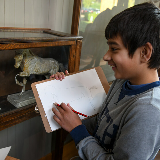 Young boy sketching in the Sculpture Gallery