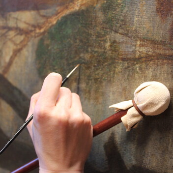 Close up of conserver's hand painting