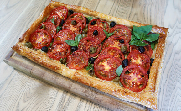 Tomato and olive tart decorated with basil leaves