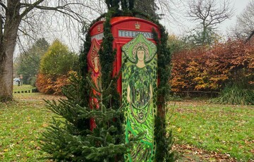 The Compton Phone box seen from an angle with the green angel on display