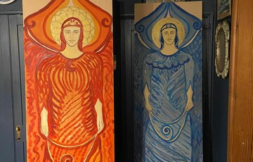 Two of the Compton angels, one painted red, the other blue, resting against a wall