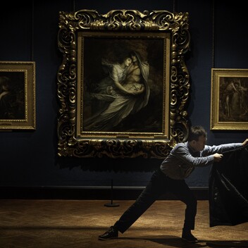 Dancer holding a jacket in a historic gallery setting