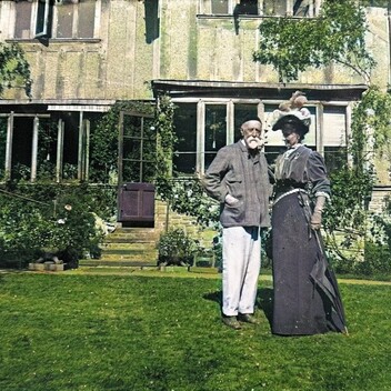 A colour photograph of George and Mary Watts stood outside Limnerslease on the lawn