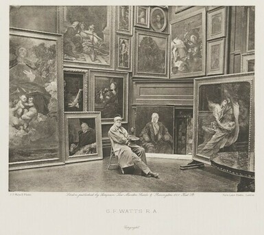 A black and white photograph of George Watts sitting on a chair in his studio surrounded by his paintings