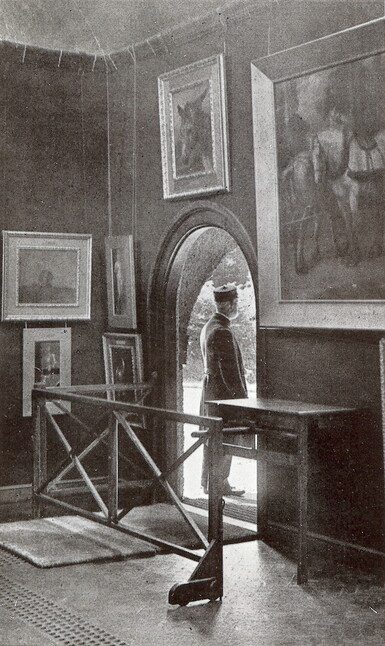 A black and white photograph of man stood in the door way of Watts Gallery