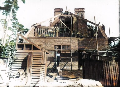 A colour photograph of Limnerslease being constructed by men working hard on the roof