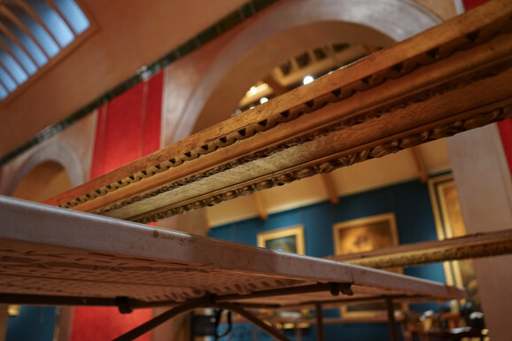 Close-up image of a gold frame on a table waiting for glass