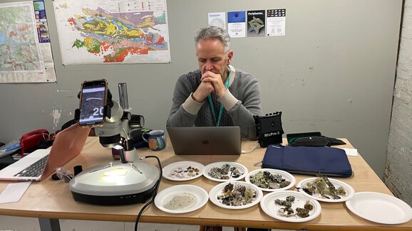 Photo of Joseph Young sitting at a desk with a laptop in front of him