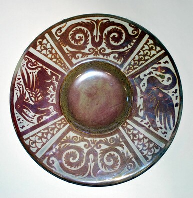 Decorative lustreware dish featuring a maroon and cream coloured geometric design as well as a dragon and a swan