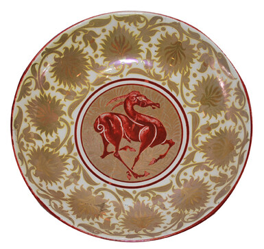 Photo of a lustreware plate featuring a horse in the middle. There is a gold floral decorative design surrounding the horse