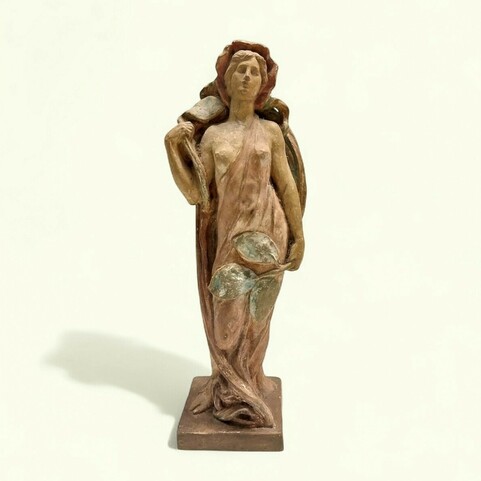 A graceful art nouveau terracotta statue of a woman, possibly a nymph or goddess, in shades of reddish-brown and muted green. She stands draped in fabric, holding large leaves, with a serene expression.