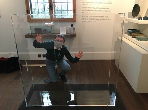 A woman posing behind a glass display case