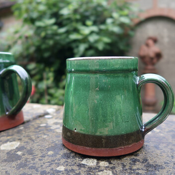 A brown and green glazed ceramic mug