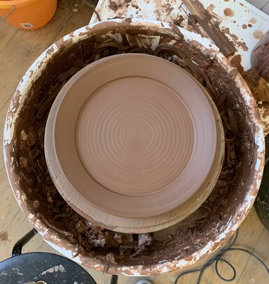 A clay plate on the pottery wheel in progress