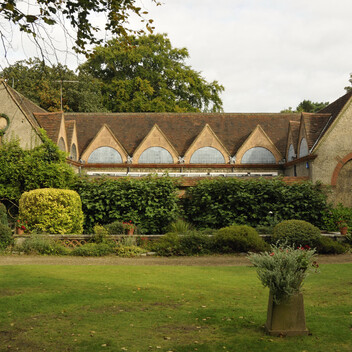 The gallery exterior features overgrown plants, the building has triangular roofs