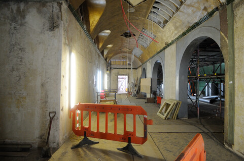 A room in a construction phase, with bare concrete walls and scaffolding
