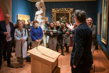 Xa, Director of the Ashmolean stands at the podium, he addresses a group of people in the gallery