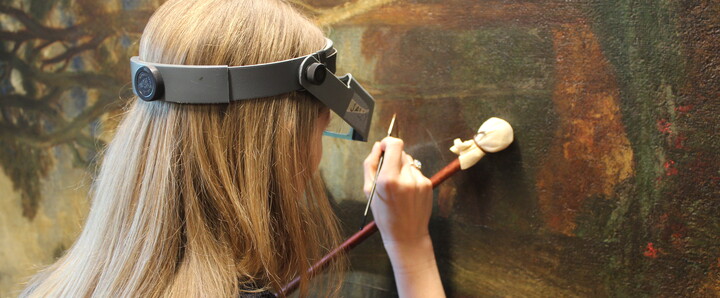Conservator uses brush to restore painting