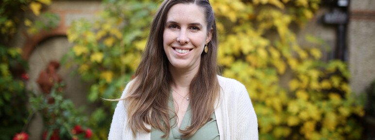 Kate stands outside the gallery smiling to camera