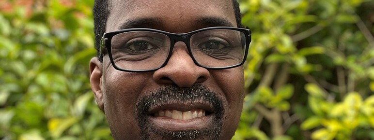 Photo of Ulric Neblett-Leigh, man with glasses and beard in a suit