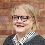 Lady with dark round glasses and blonde hair