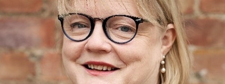 Lady with dark round glasses and blonde hair