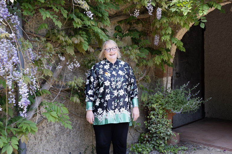 A photo of Sarah King, a lady with short blonde hair wearing glasses and a patterned shirt