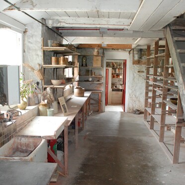 Photo of a small pottery studio with low ceilings