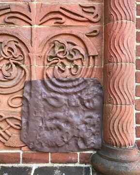 Clay is pressed onto the patterned tiles of Watts Cemetery Chapel