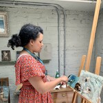 Nneka painting on an easel