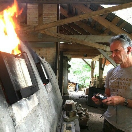 Photo of Joseph Young in front of a furnace recording the sound