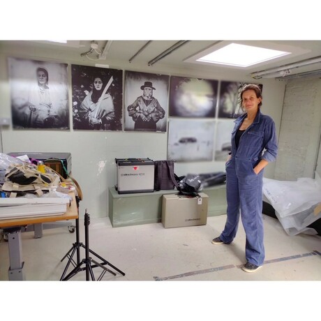 Photo of artist Emma Brown wearing blue overalls in an art studio
