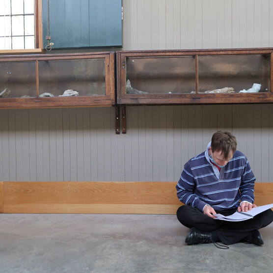 A man sits on the floor in the gallery