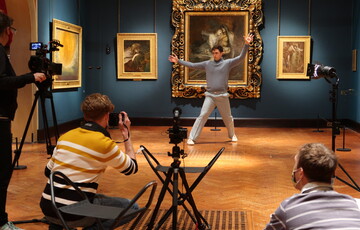 A dancer for Chris Pavia's Beyond the Waves dances in front of Francesca and Paolo. A crew photograph and film him in the foreground