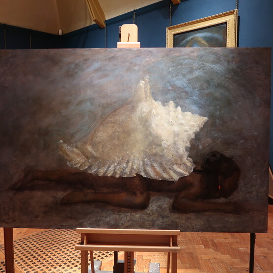 An oil painting on an easel of a large sea shell on the back of a sprawled, dark figure.
