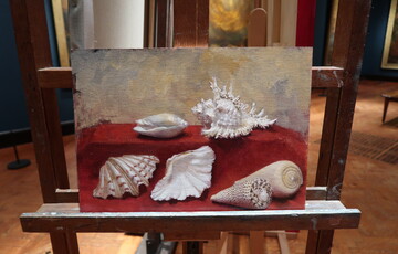 An oil painting on an easel of a collection of large sea shells on a red cloth