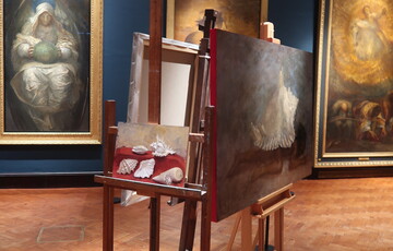 Two paintings on wooden easels in gallery