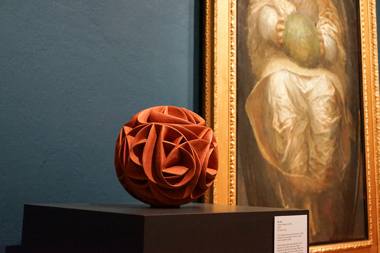 Photo of a spherical terracotta sculpture with curved ridges
