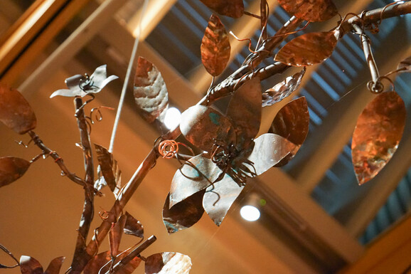 Close up image of a copper sculpture of flowers and vines