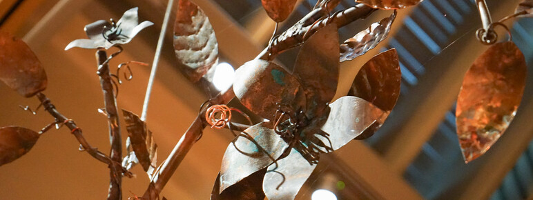 Close up image of a copper sculpture of flowers and vines