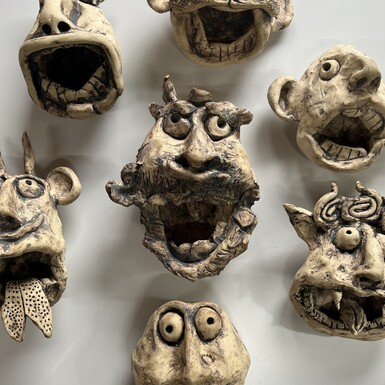 A collection of ceramic faces with unusual expressions