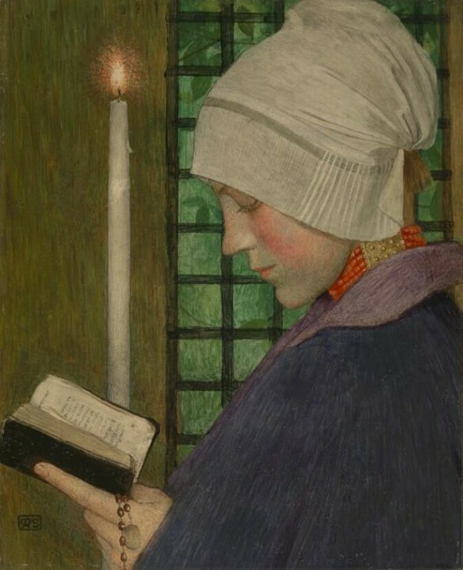 A women reading a book by candlelight