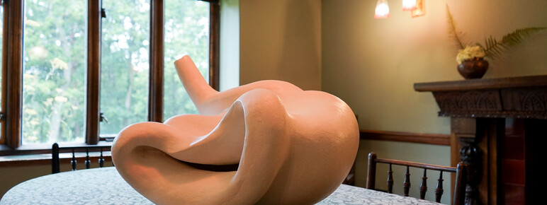 Photo of a white abstract ceramic sculpture placed on a dining room table
