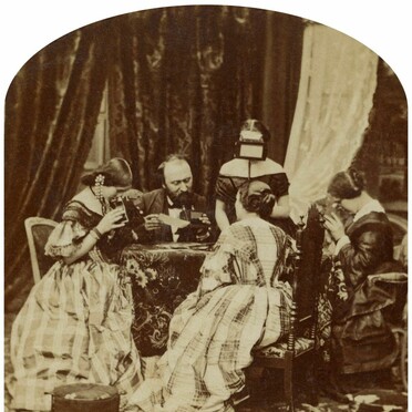Stereo photograph of a Victorian family looking at stereo photographs and stereoscopes