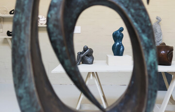 A shot of two sculptures taken through the centre of a third during the 2022 Figure and Form exhibition