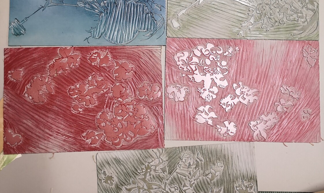 Five etched print blocks stained in various different colours