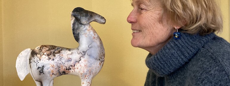 Artist Alison Wear looks into the eyes of the ceramic horse she has made