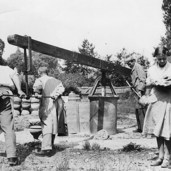 Black and white photo of workers operating mill