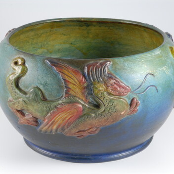 Blue and green bowl with yellow inside decorated with a red and green dragon on the outside